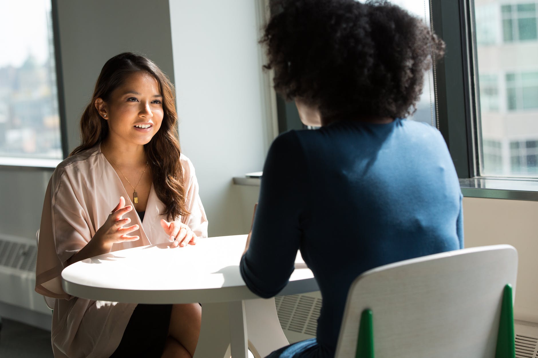 Two BIPOC women talking at a table