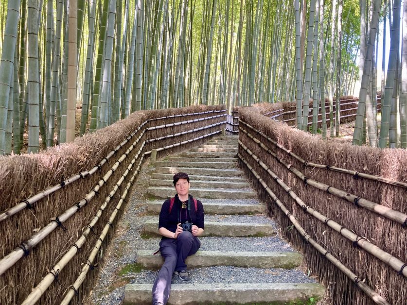 Lindsey sitting on stairs in a bamboo forest.