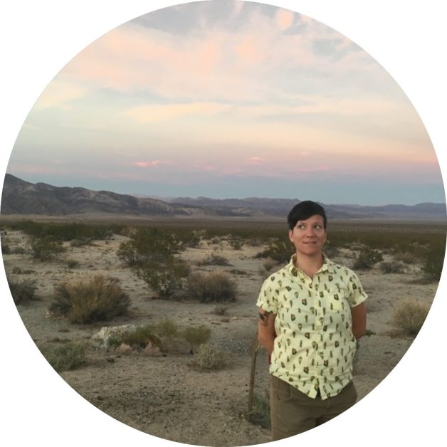 Circular image of white person in yellow shirt standing in the desert 
