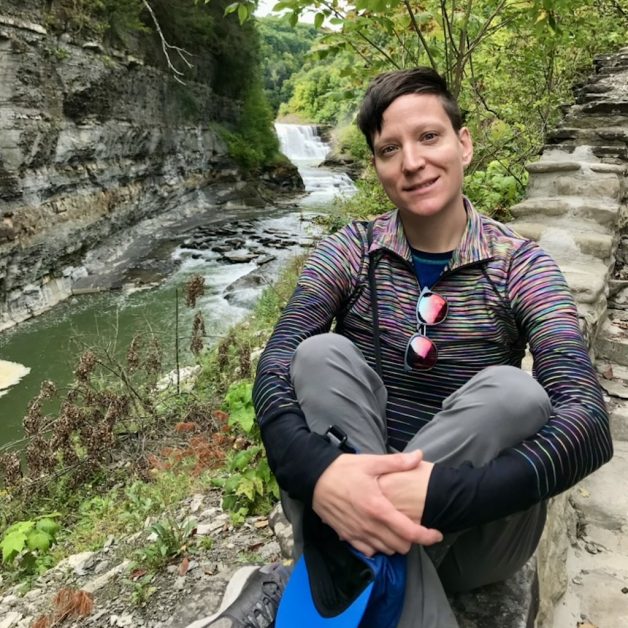 Lindsey sitting beside a river. 